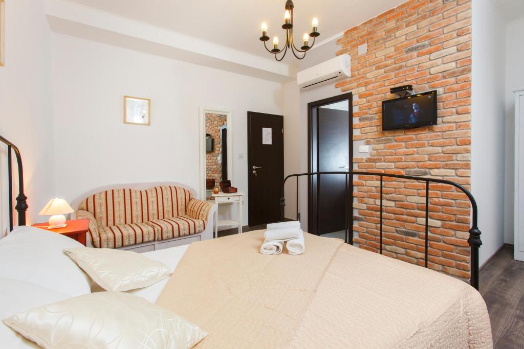 a bedroom with a bed and a brick wall at Prior Suites Split in Split