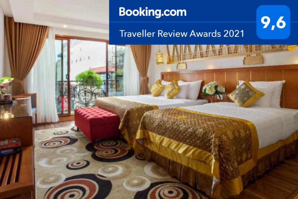 a hotel room with two beds and a red stool at Hanoi Golden Holiday Hotel in Hanoi