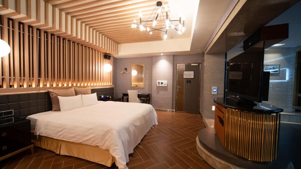 um quarto com uma cama e uma televisão de ecrã plano em I-more Motel em Yonghe