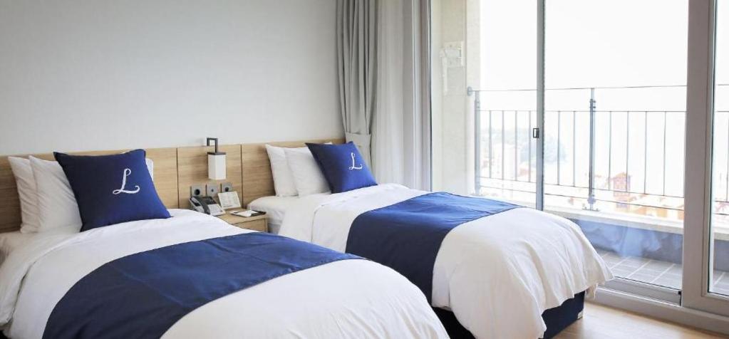 Postel nebo postele na pokoji v ubytování Lapis Hotel Namhae