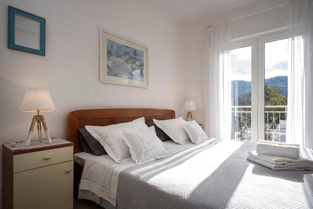 sypialnia z dużym łóżkiem i oknem w obiekcie Apartments Bogdanić w mieście Stari Grad
