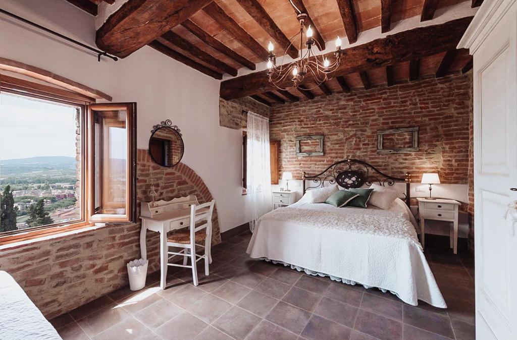 a bedroom with a bed and a brick wall at Antica Torre del Borgo in Certaldo