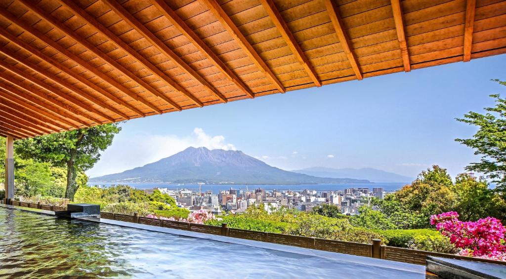 una piscina con vistas a la montaña en SHIROYAMA HOTEL kagoshima, en Kagoshima