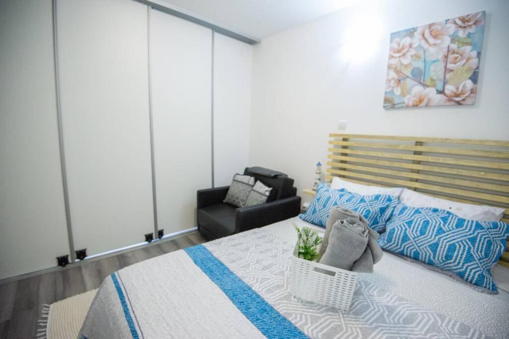a bedroom with a bed and a chair in a room at GreenEscapes II in Porto Covo