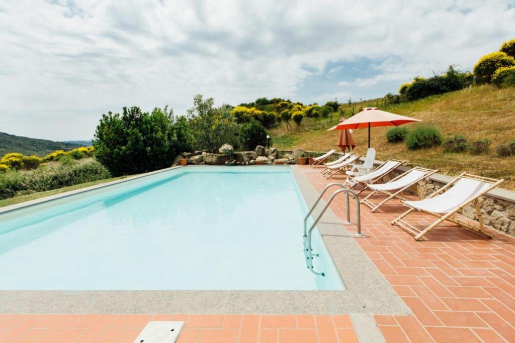 - une piscine avec des chaises longues et un parasol dans l'établissement 6 bedrooms villa with private pool and furnished terrace at Santa Fiora, à Santa Fiora