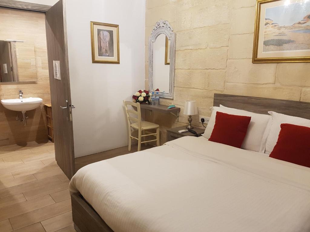 sypialnia z łóżkiem oraz łazienka z umywalką w obiekcie Point de vue Guesthouse w mieście Rabat