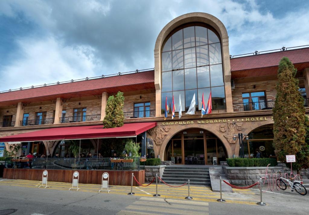 a building with flags in front of it at Kecharis Hotel and Resort in Tsaghkadzor