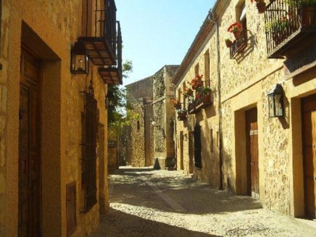 an empty alley with buildings in an old town at Apartamento El Desván in Pedraza-Segovia