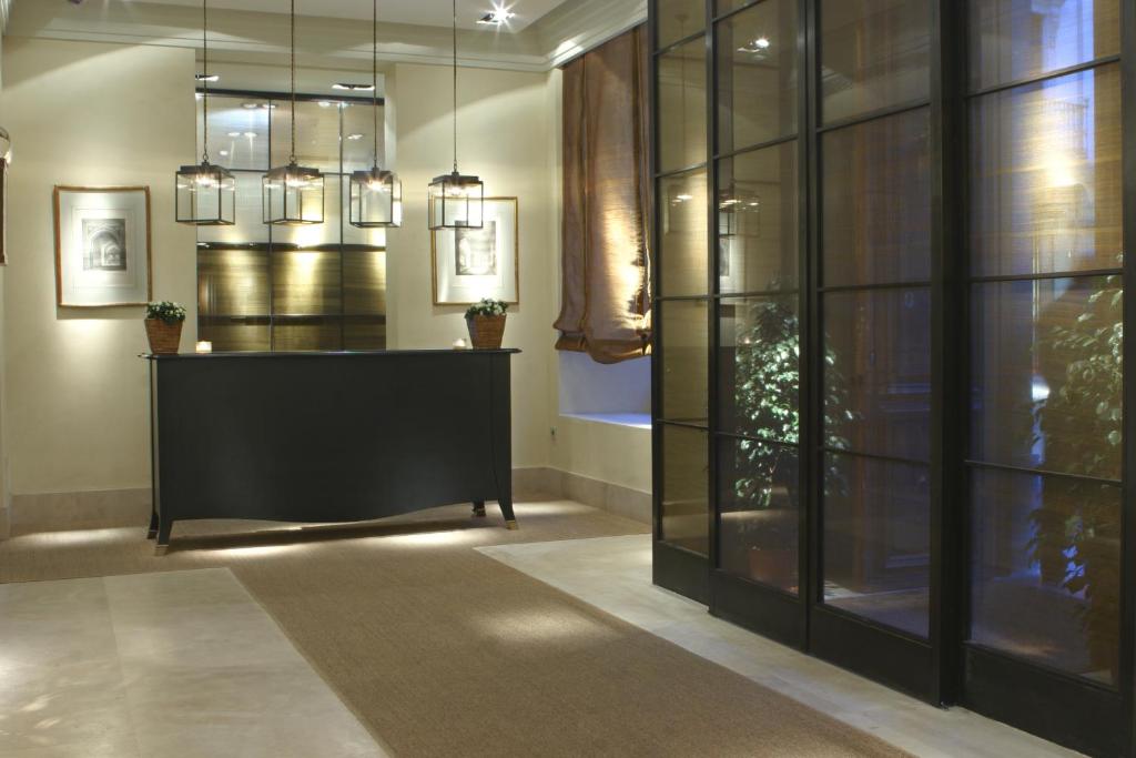 a lobby with a reception desk and chandeliers at Villa Oniria in Granada