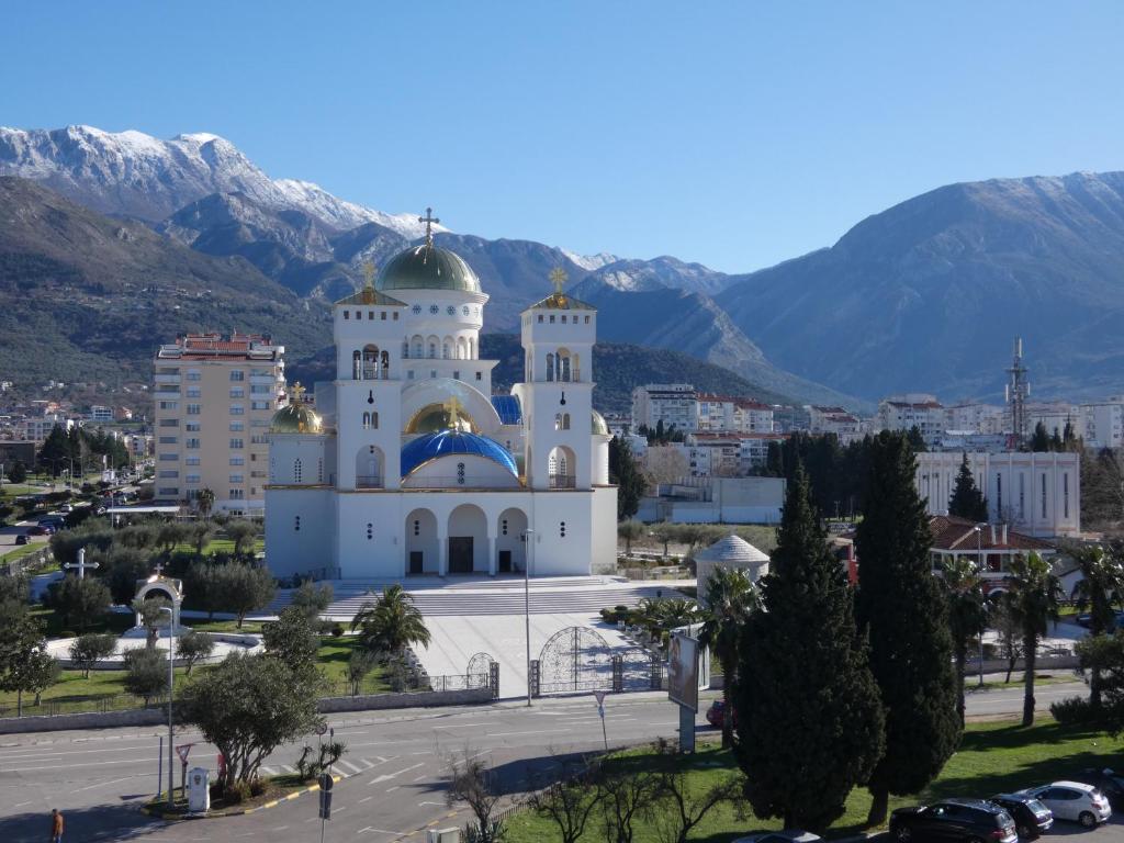 a church in a city with mountains in the background at Hotel Princess in Bar