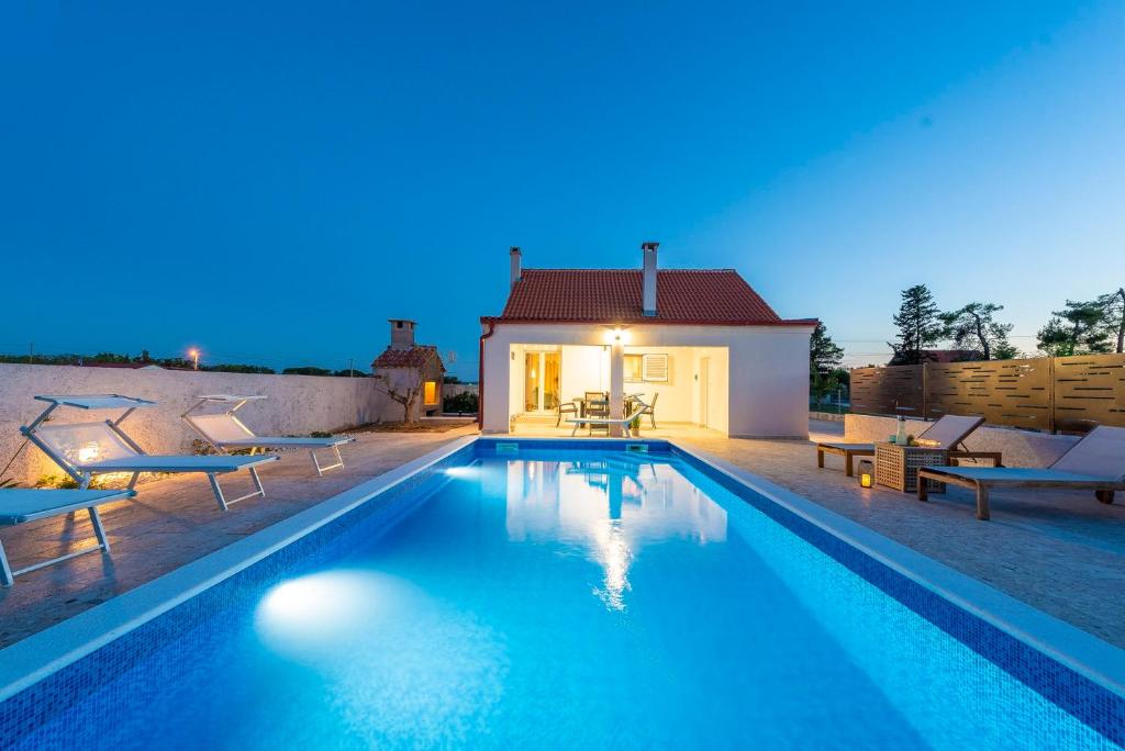 una piscina frente a una casa por la noche en Villa Mirabella en Smoković