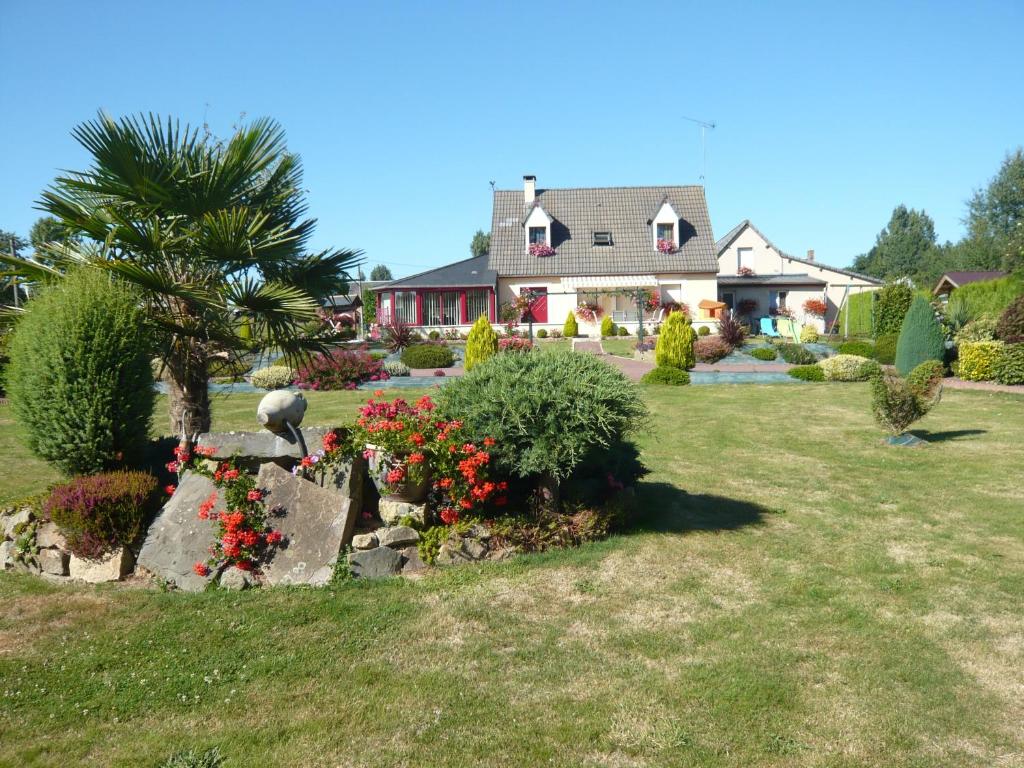a house with a garden with flowers in the yard at Chambres d'Hotes La Maison Neuve in Saint-Loup