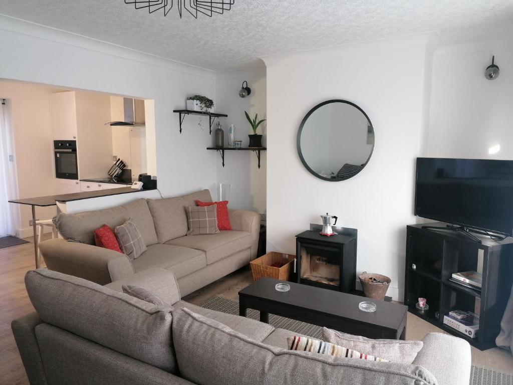 a living room with a couch and a mirror at Two Sails Brixham - Spacious modern family seaside home - parking - wood-burner - dog friendly in Brixham