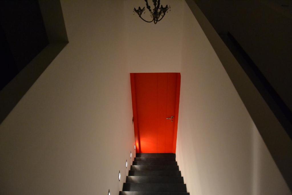 a stairway with a red door and a red wall at B&B Torre Porta Marina in Ventimiglia