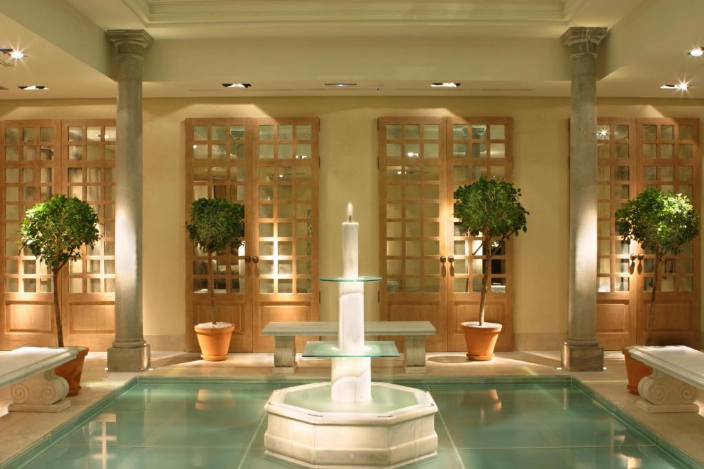 a lobby with a fountain in the middle of a pool at Villa Oniria in Granada