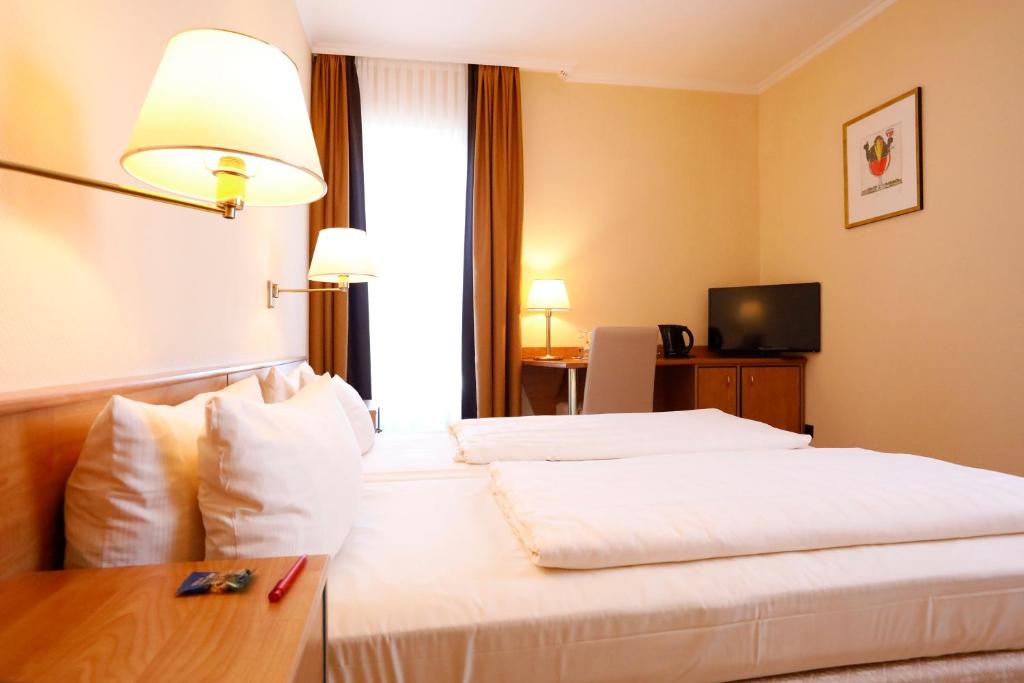 Postel nebo postele na pokoji v ubytování Kurpark-Hotel