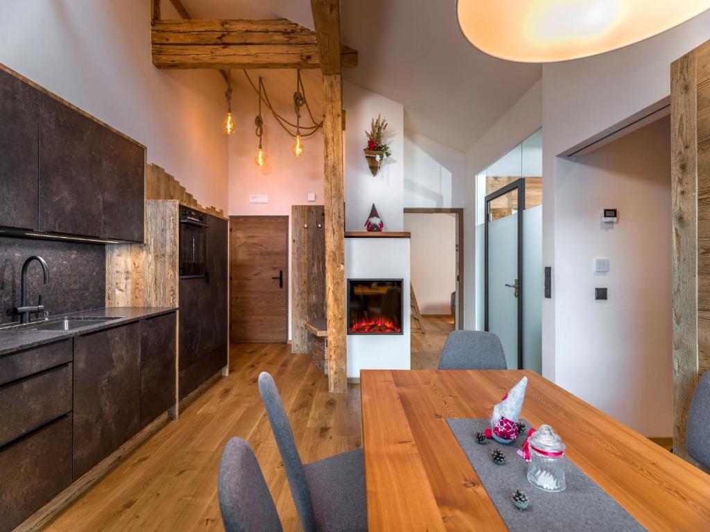 uma cozinha e sala de jantar com uma mesa de madeira e cadeiras em Hofchalet Heu - Örlerhof em Prateria