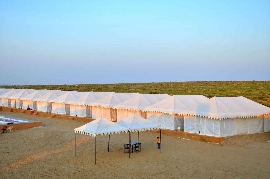 una fila di tende bianche sedute su una spiaggia di Sky Desert Safari & Spa a Sām