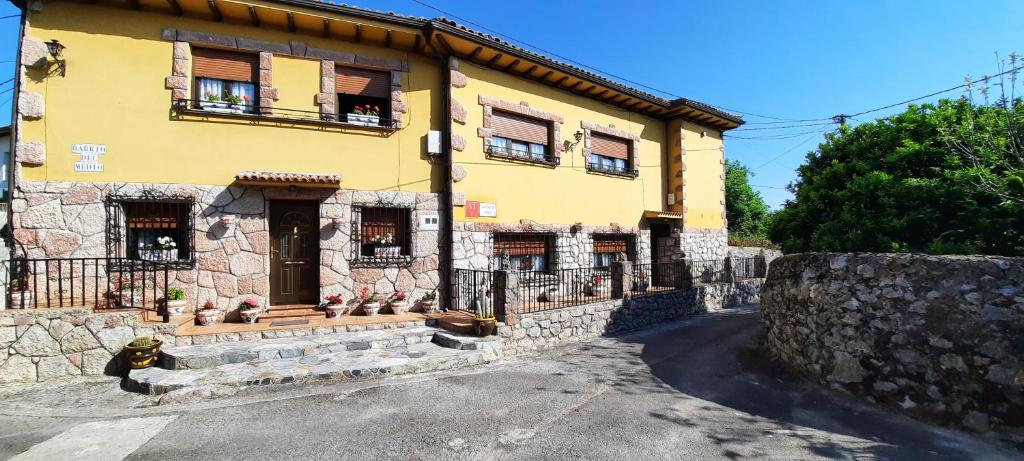 un gran edificio amarillo con ventanas en una calle en Apartamentos Carolina, en Celorio