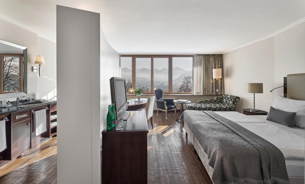 a hotel room with a large bed and a kitchen at Lebenberg Schlosshotel-Kitzbühel in Kitzbühel