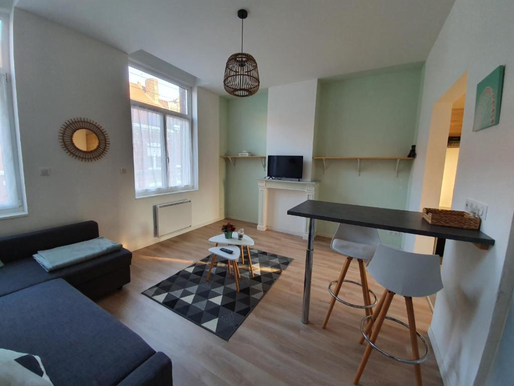 een woonkamer met een bank en een tafel bij Appartement calme, chaleureux et lumineux in Douai
