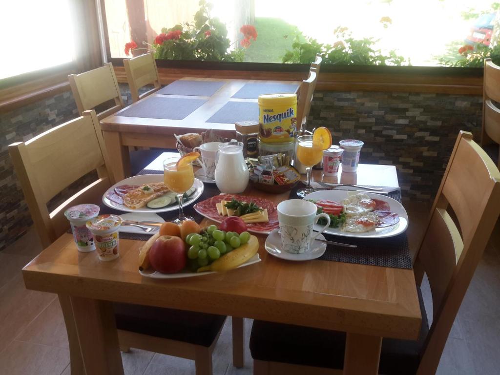a wooden table with breakfast foods and drinks on it at Lake House 1 in Plitvička Jezera