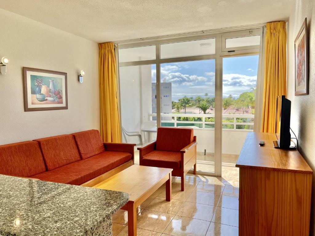 ein Wohnzimmer mit einem Sofa und einem TV in der Unterkunft Seaview Friendly Holiday Home 9 in Playa del Ingles