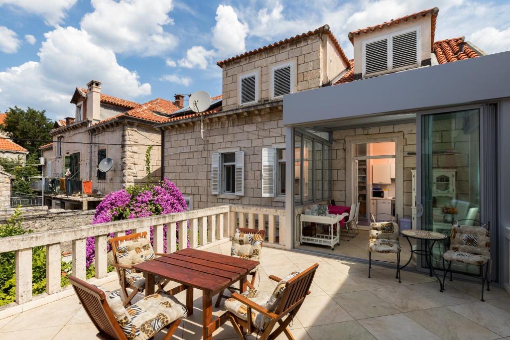 une terrasse avec une table et des chaises ainsi qu'une maison dans l'établissement Apartment Van Gogh, à Dubrovnik