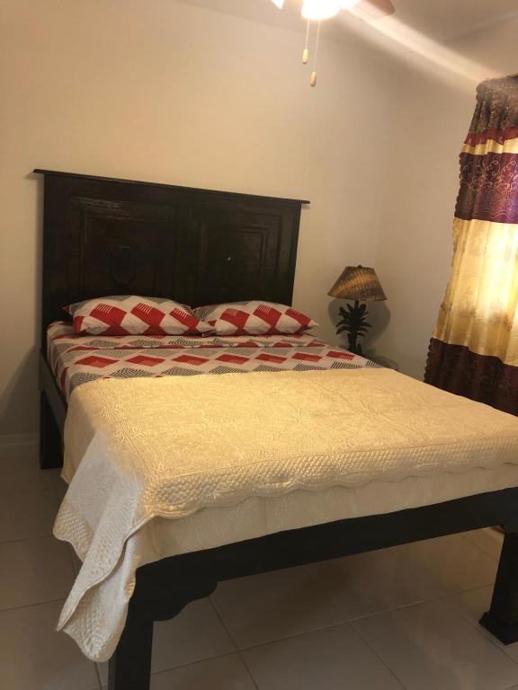 Un dormitorio con una cama con almohadas rojas. en Courage, en Nassau