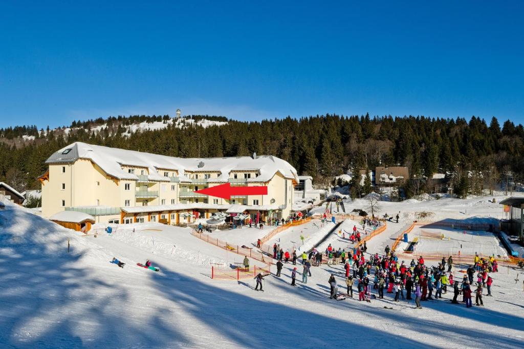 a group of people standing in the snow in front of a ski lodge at Ferienwohnung Feldberg - Residenz Grafenmatt in Feldberg