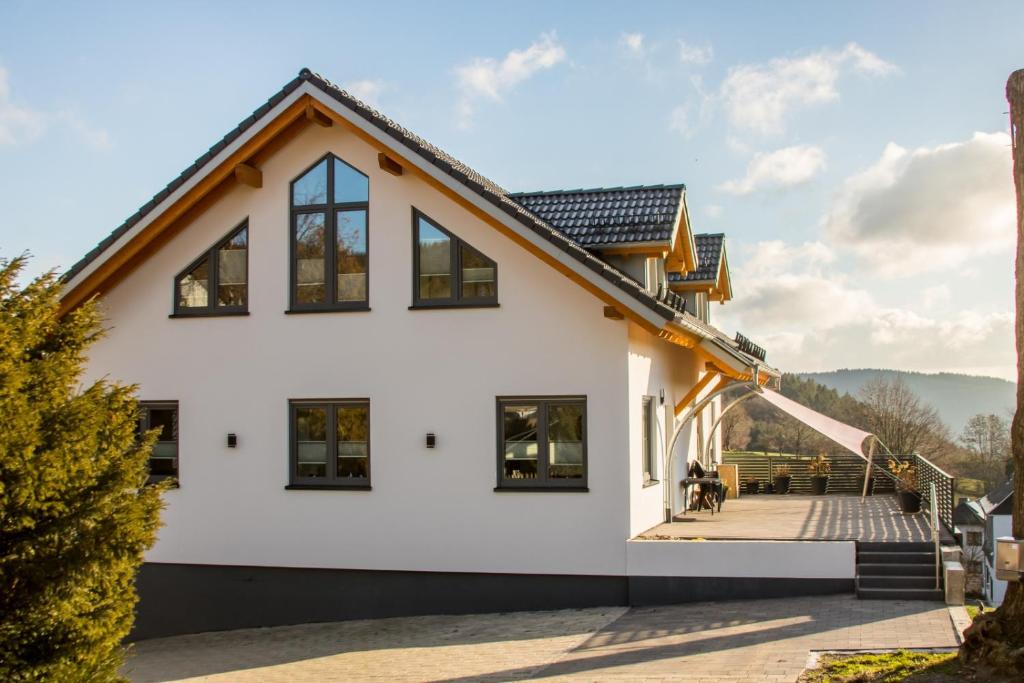 una casa bianca con tetto marrone di Ferienwohnung Stratmann a Lennestadt