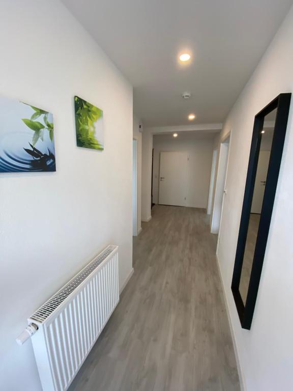 an empty hallway with white walls and wood floors at Schöne Ferienwohnung in Landsberg in Landsberg