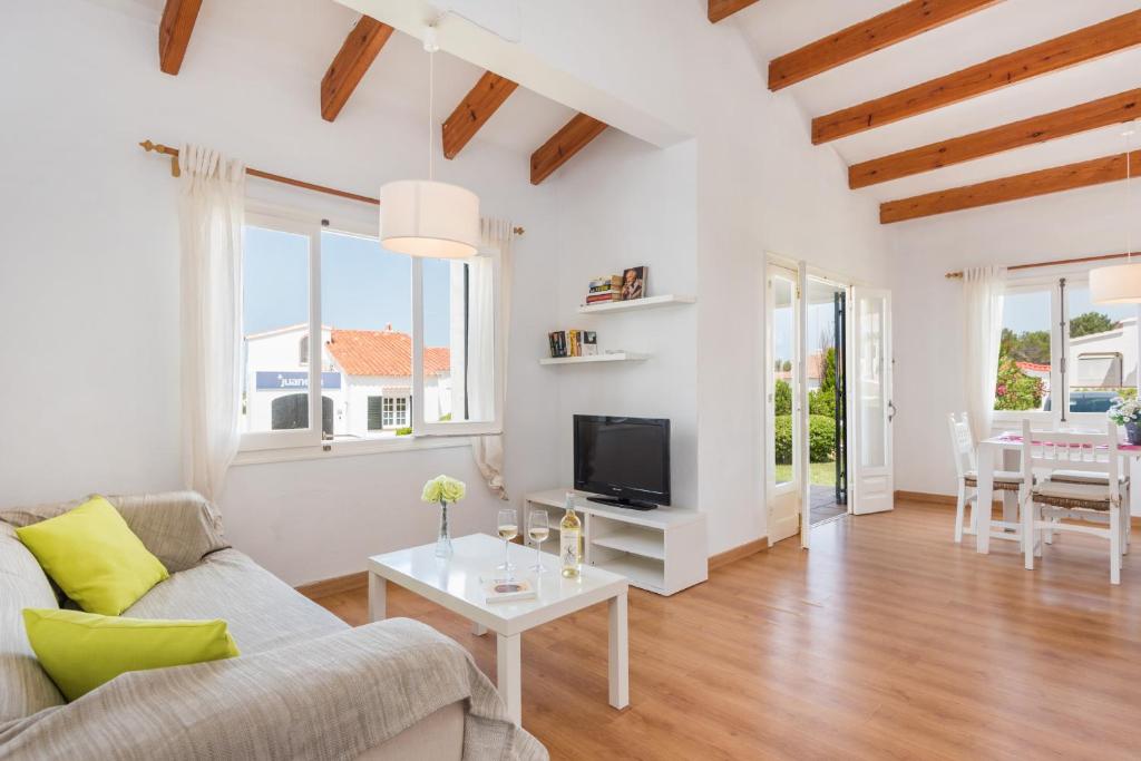 ein Wohnzimmer mit einem Sofa und einem Tisch in der Unterkunft Apartamento Savina-Arenal den Castell in Es Mercadal