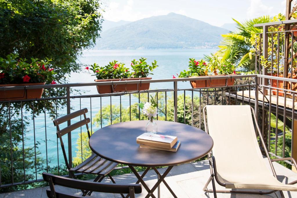 una mesa y sillas en un balcón con vistas al agua en Residenza Leonardo, en Luino