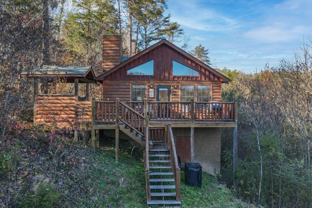 Cabaña de madera con una escalera que conduce a una terraza en Secluded Cabin Near Smoky Mountains. Hot Tub! Honeymoon! en Sevierville