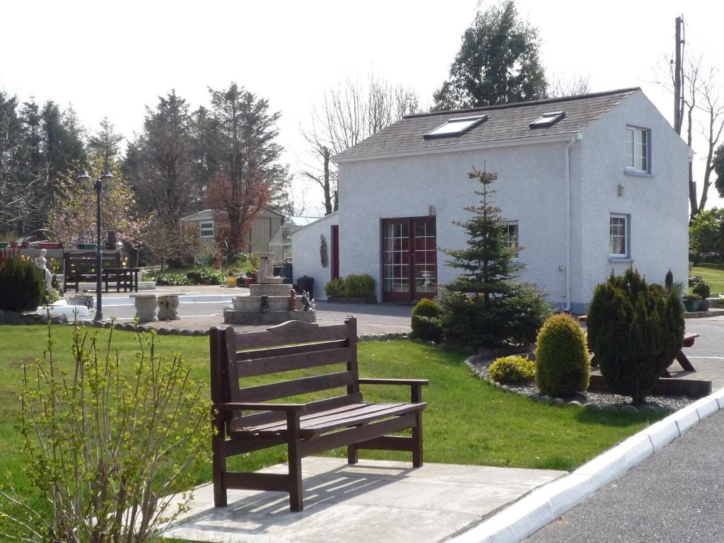 a park bench in front of a white building at Island View Cottage Bantry in Bantry