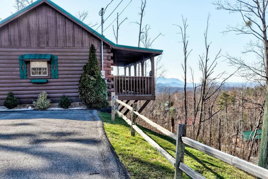a log cabin with a porch and a fence at Amazing Views! Hot Tub,Pool Table,Fireplace,Relax! in Gatlinburg