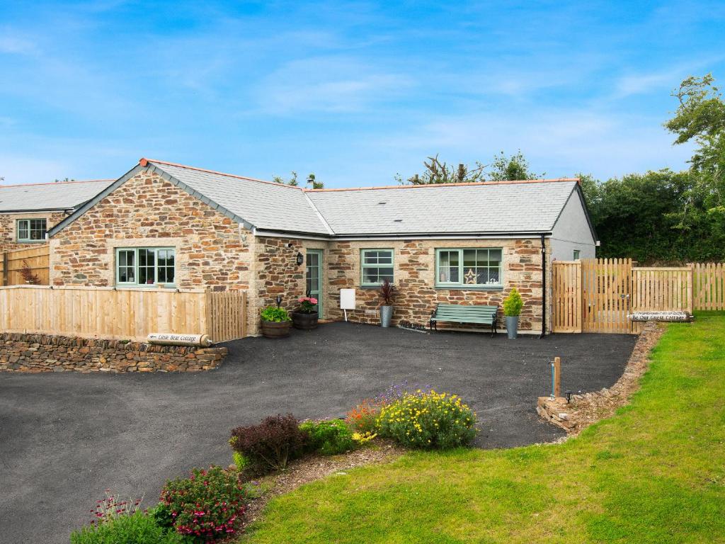 a stone house with a patio and a fence at Be Our Guest Cottage in Truro