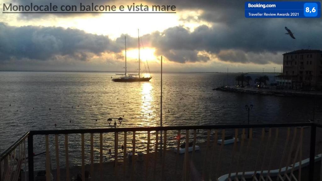 um veleiro na água com o pôr do sol em Casa Vacanze Monte Argentario em Porto Santo Stefano