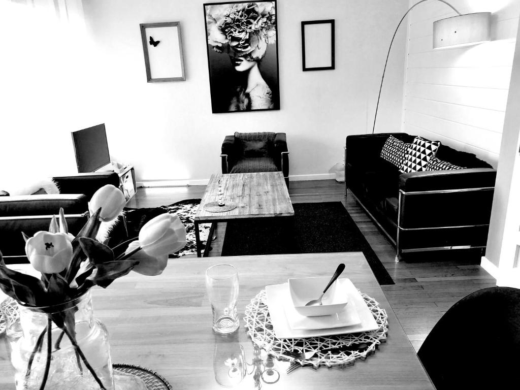 un salon avec un canapé et une table avec des fleurs dans l'établissement Bed and Break Annecy, appartement 90m2 avec parking, balcons, à Annecy