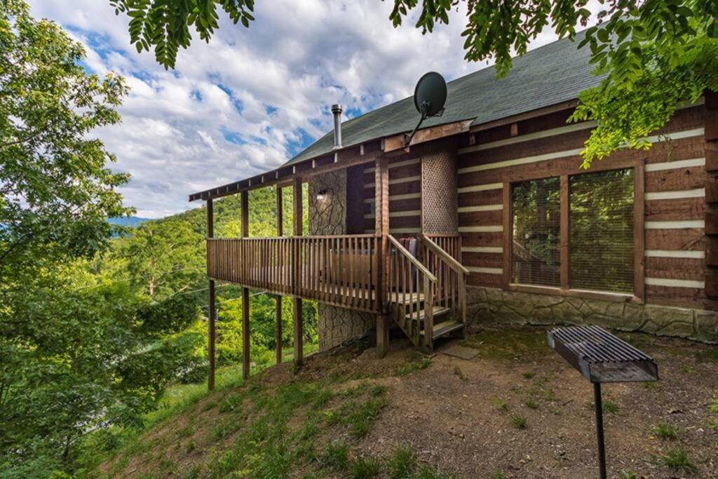ein Blockhaus mit einer großen Terrasse im Wald in der Unterkunft View! Private! Hot Tub,Pool Table,Fireplace,RELAX! in Sevierville