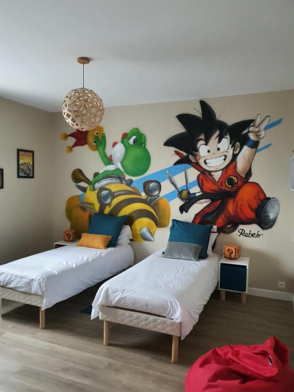a bedroom with two beds and a mural of sonic at LES 5 ESCALES in Parthenay