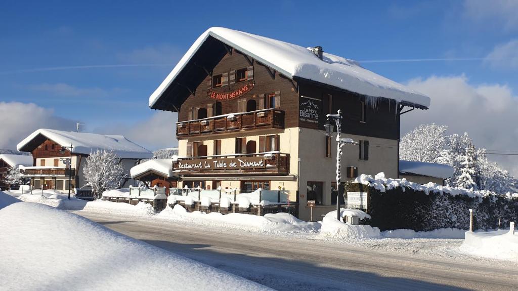 un grand bâtiment avec de la neige sur le côté d'une route dans l'établissement Chalet Hotel Le Mont Bisanne, à Crest-Voland