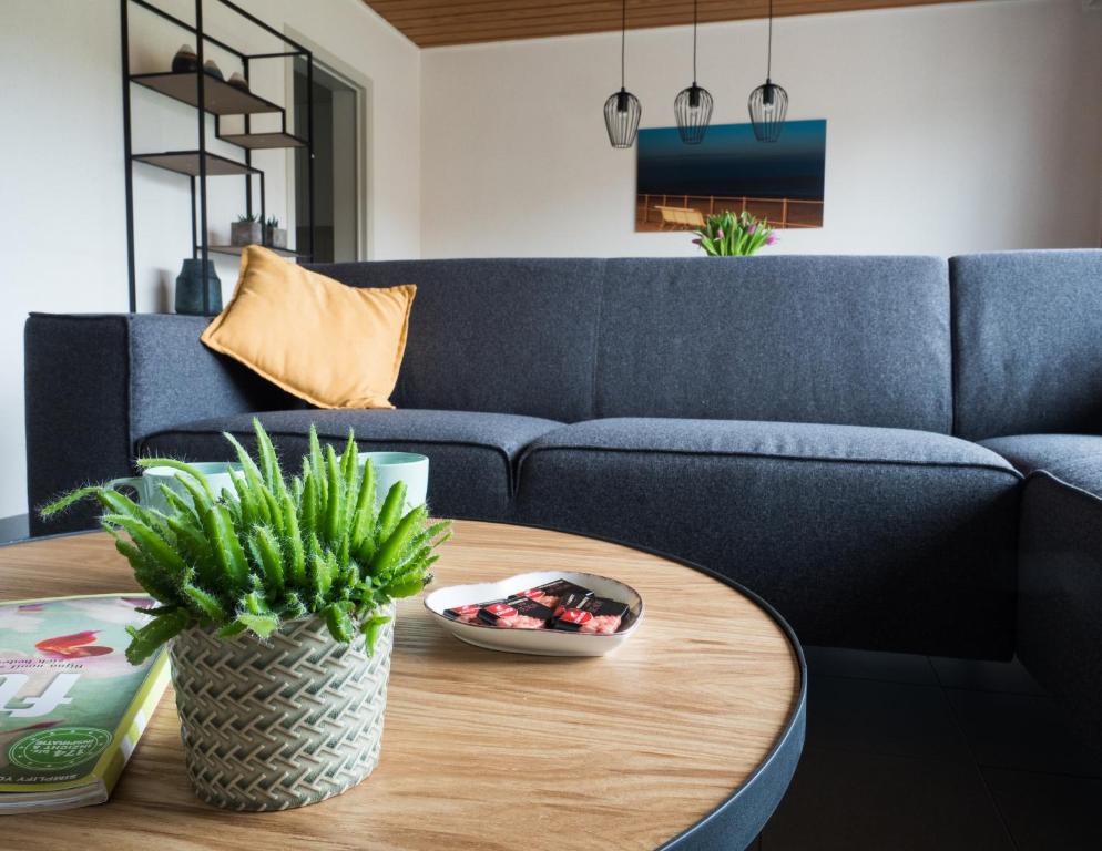 ein Wohnzimmer mit einem blauen Sofa und einem Tisch in der Unterkunft Appartementen Bredene in Bredene-aan-Zee