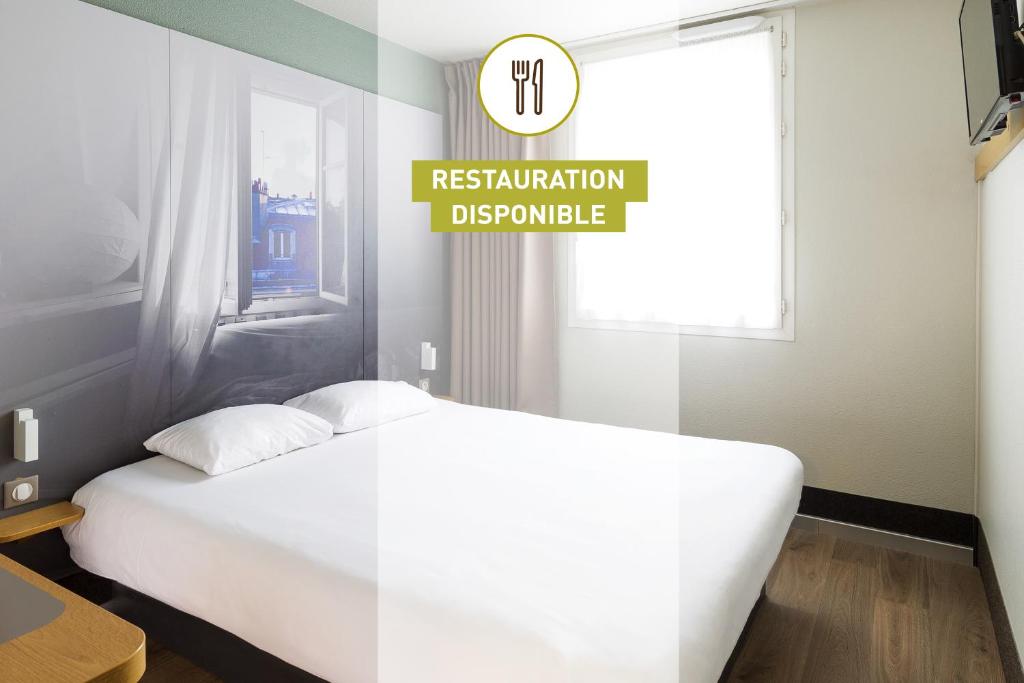 um quarto com uma cama branca e uma placa que lê restauração buquerque em B&B HOTEL Angoulême em Le Gond-Pontouvre