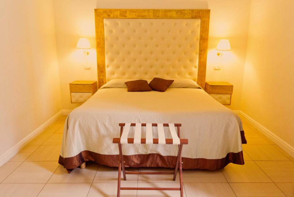1 Schlafzimmer mit einem großen Bett und 2 Stühlen in der Unterkunft Caput Mundi Suite in Rom