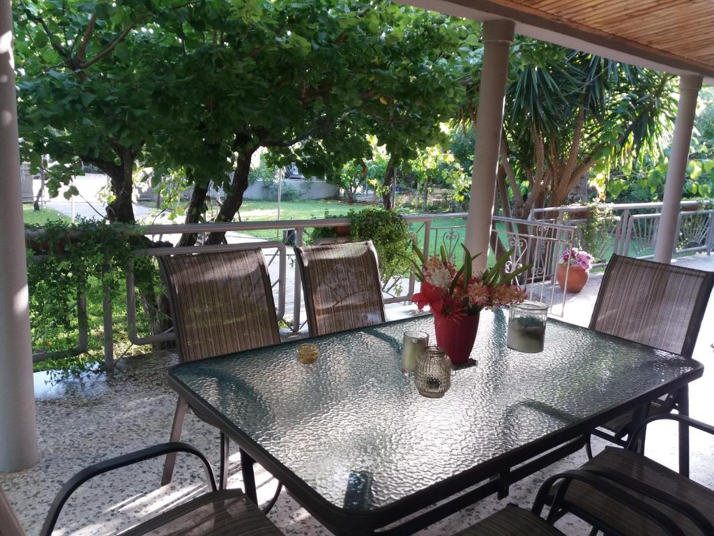 uma mesa de vidro e cadeiras num pátio em Beach House for up to 9 people near Olympia em Katakolon