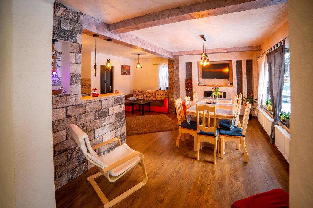uma sala de jantar e sala de estar com mesa e cadeiras em Casa Danielle em Topliţa