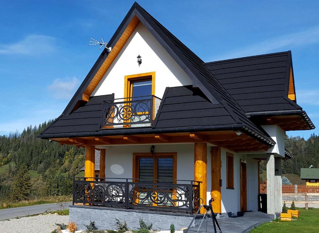 a small house with a black roof at Domek Lilijka in Poronin