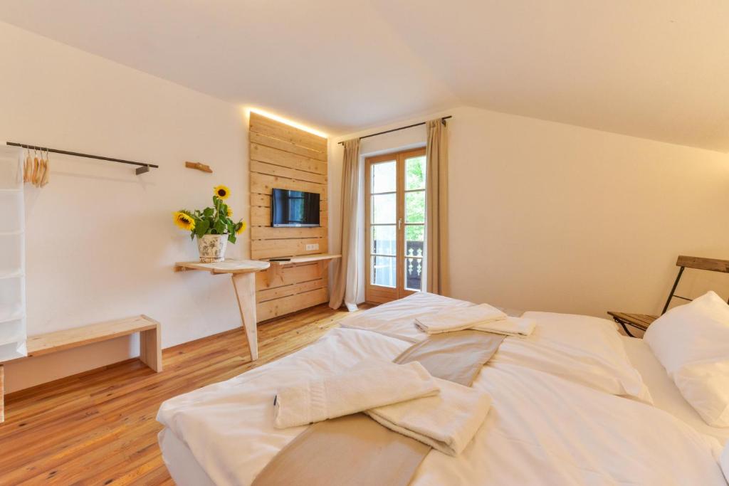 a large white bed in a room with a window at RamsAu-das Gasthaus in Bad Heilbrunn